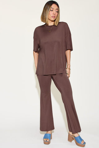 Woman wearing bamboo drop shoulder t-shirt and flare pants set in brown with blue platform sandals.