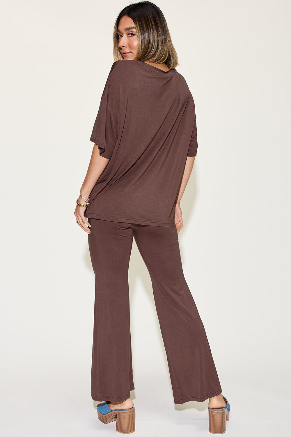 Woman modeling bamboo drop shoulder T-shirt and flare pants set in brown, showcasing comfortable fit and sustainable fashion.