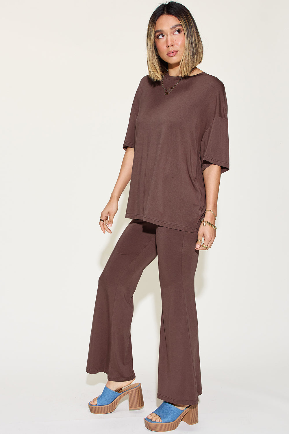 Woman wearing a brown bamboo drop shoulder t-shirt and flare pants set, showcasing a stylish and comfortable two-piece outfit.