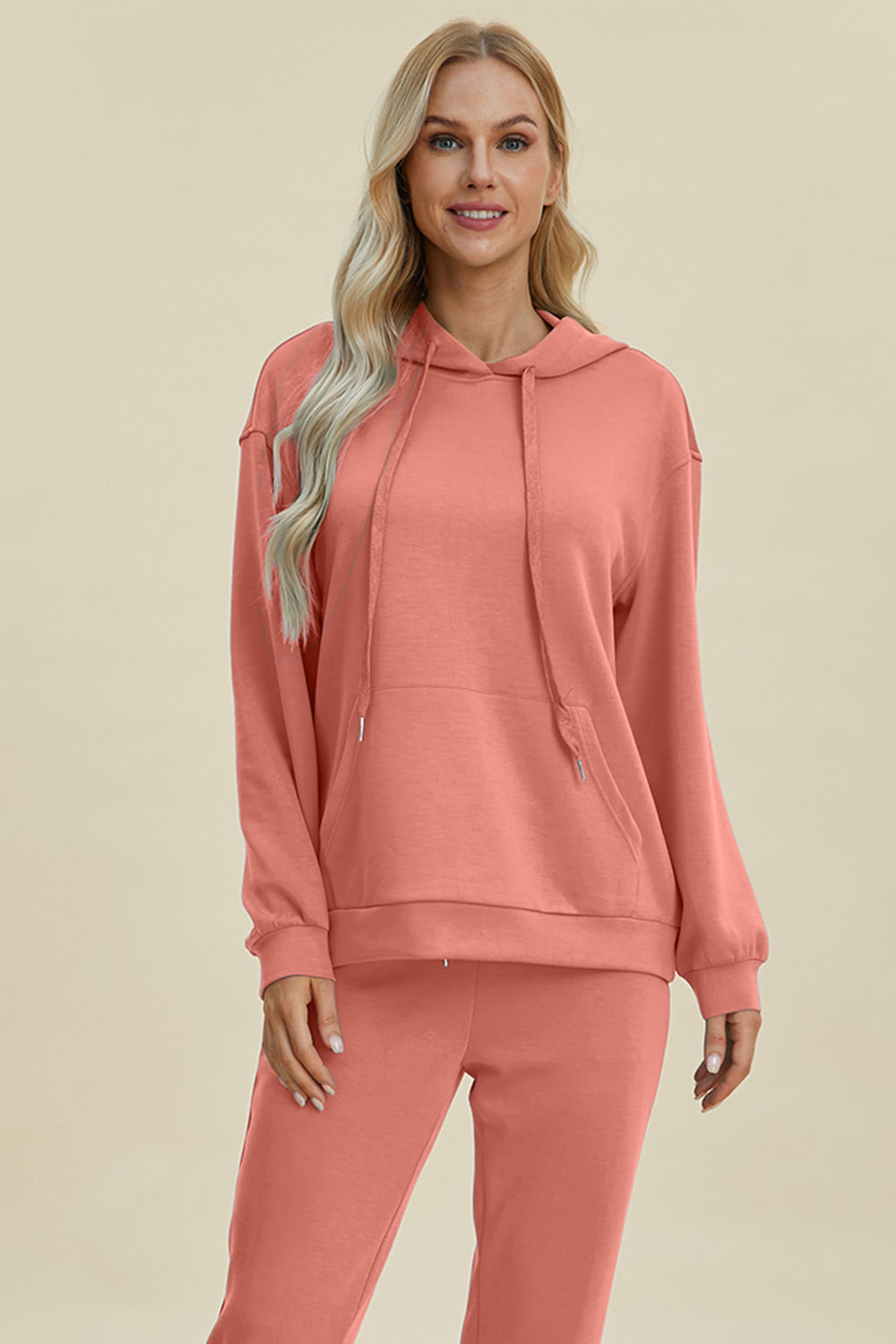 Woman wearing pink Basic Bae Air Scuba hoodie with kangaroo pocket and drawstring, paired with matching sweatpants.