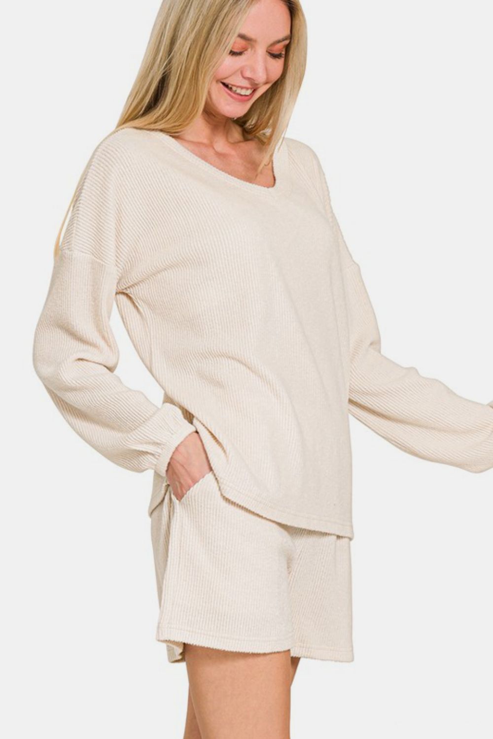 Beige V-neck ribbed top and shorts set, long sleeve, two-piece, slightly stretchy fabric, polyester-rayon-spandex blend.