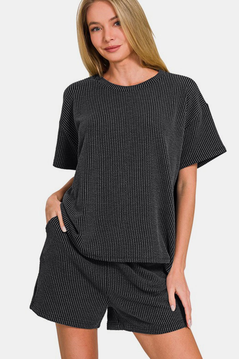 Woman wearing black ribbed short sleeve T-shirt and shorts set, slightly stretchy, two-piece outfit with basic style.