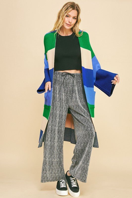 Woman wearing blue stripe color block kimono sleeve open front cardigan with pockets, basic style, made of viscose, polyester, and nylon.