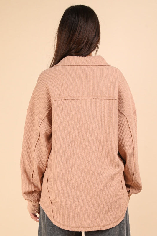 Woman wearing textured knit blush shacket with back view showing exposed seams and relaxed fit