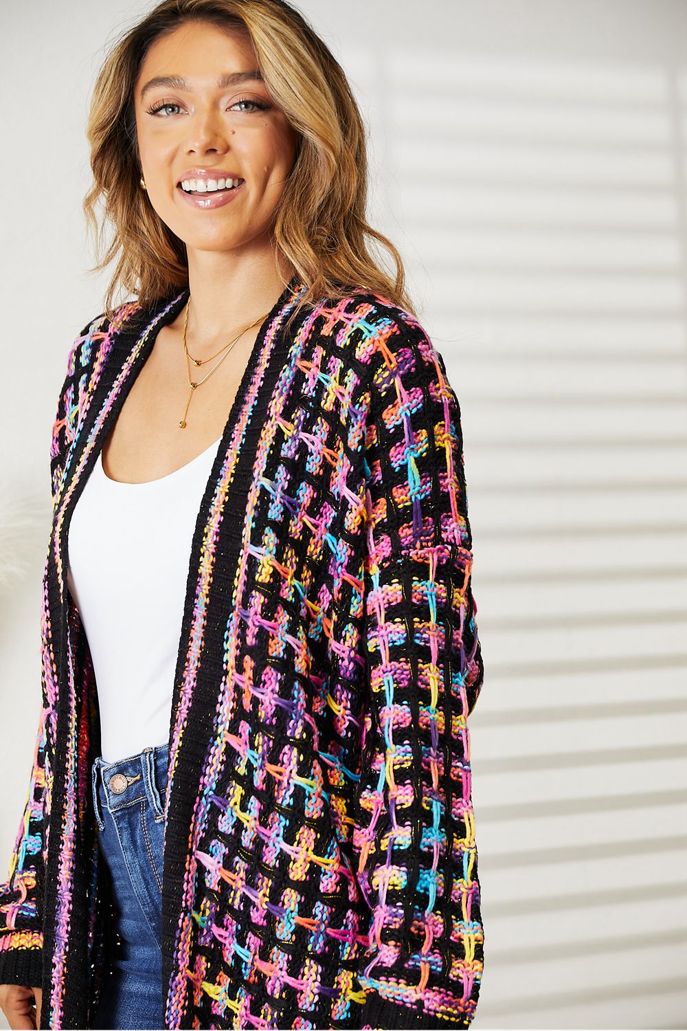 Woman wearing multicolored open front fringe hem cardigan, bohemian chic style, perfect for versatile layering and comfort.