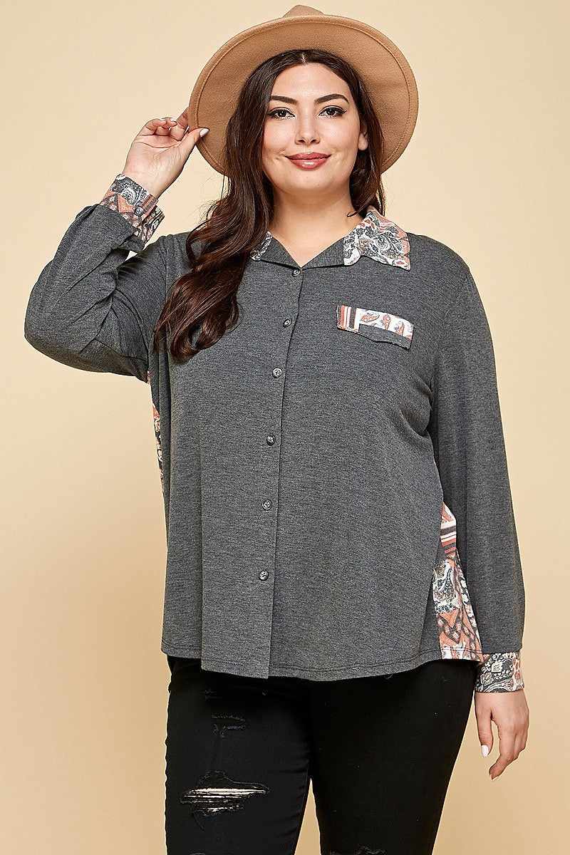 Plus size charcoal patchwork button-up shirt with spread collar and faux pocket, worn by model in a hat.