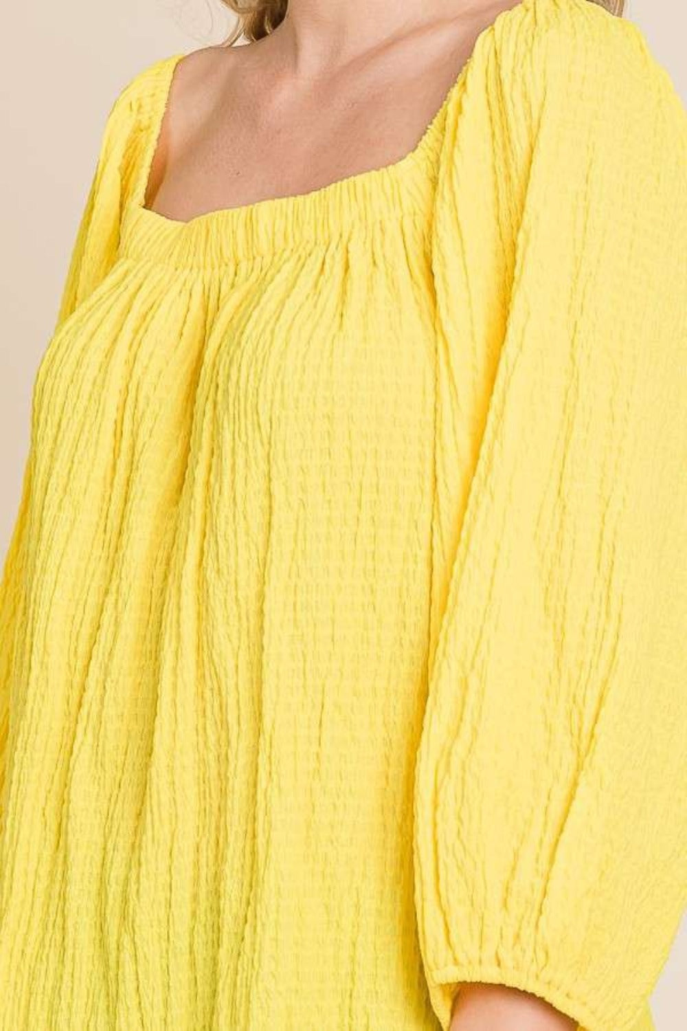 Yellow square neck puff sleeve top with ruched texture and three-quarter sleeves for an elegant and versatile look.