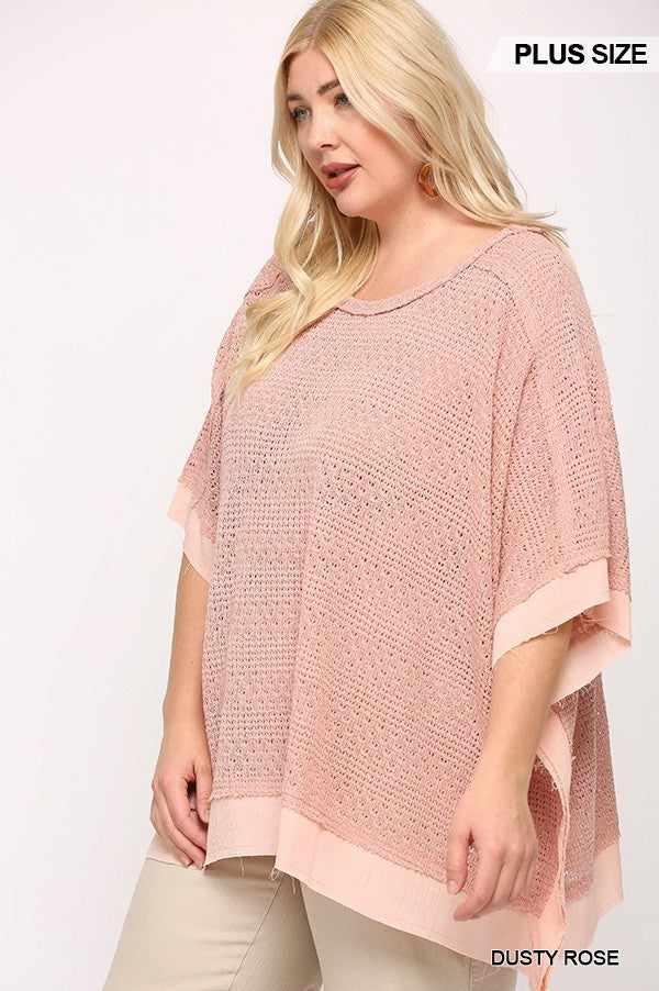 Plus size model wearing a dusty rose light knit and woven mixed boxy top with poncho sleeves, 100% polyester.