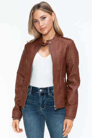 Woman wearing Brandy PU leather biker jacket with side zip pockets, basic style, paired with a white top and jeans.