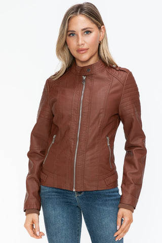 Woman wearing brown Brandy PU leather biker jacket with side zip pockets