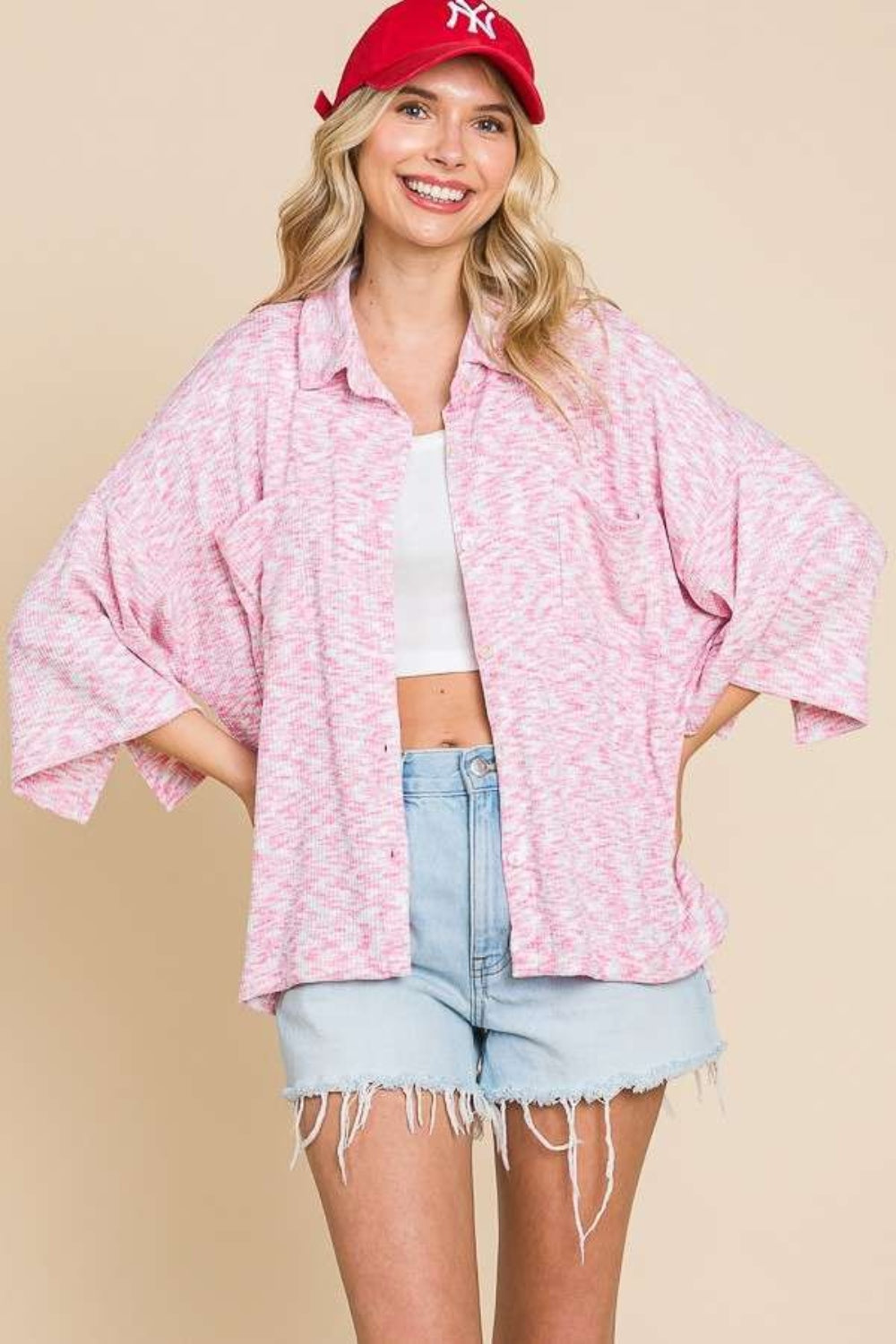 Woman wearing a pink button-up drop shoulder slit shirt with a casual style, featuring a basic design and slightly stretchy material.