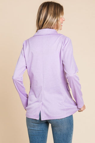Woman wearing a lilac button-up long sleeve slit blazer made of polyester and spandex, showcasing its sleek back design.