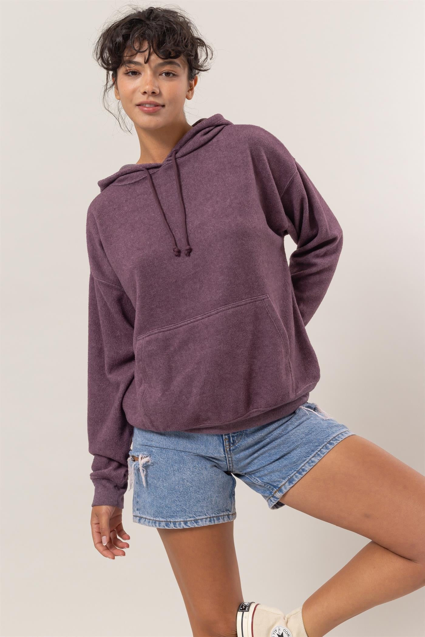 Dark plum brushed long sleeve hoodie with kangaroo pocket, featuring drawstrings and slight stretch, worn by model in casual jeans.