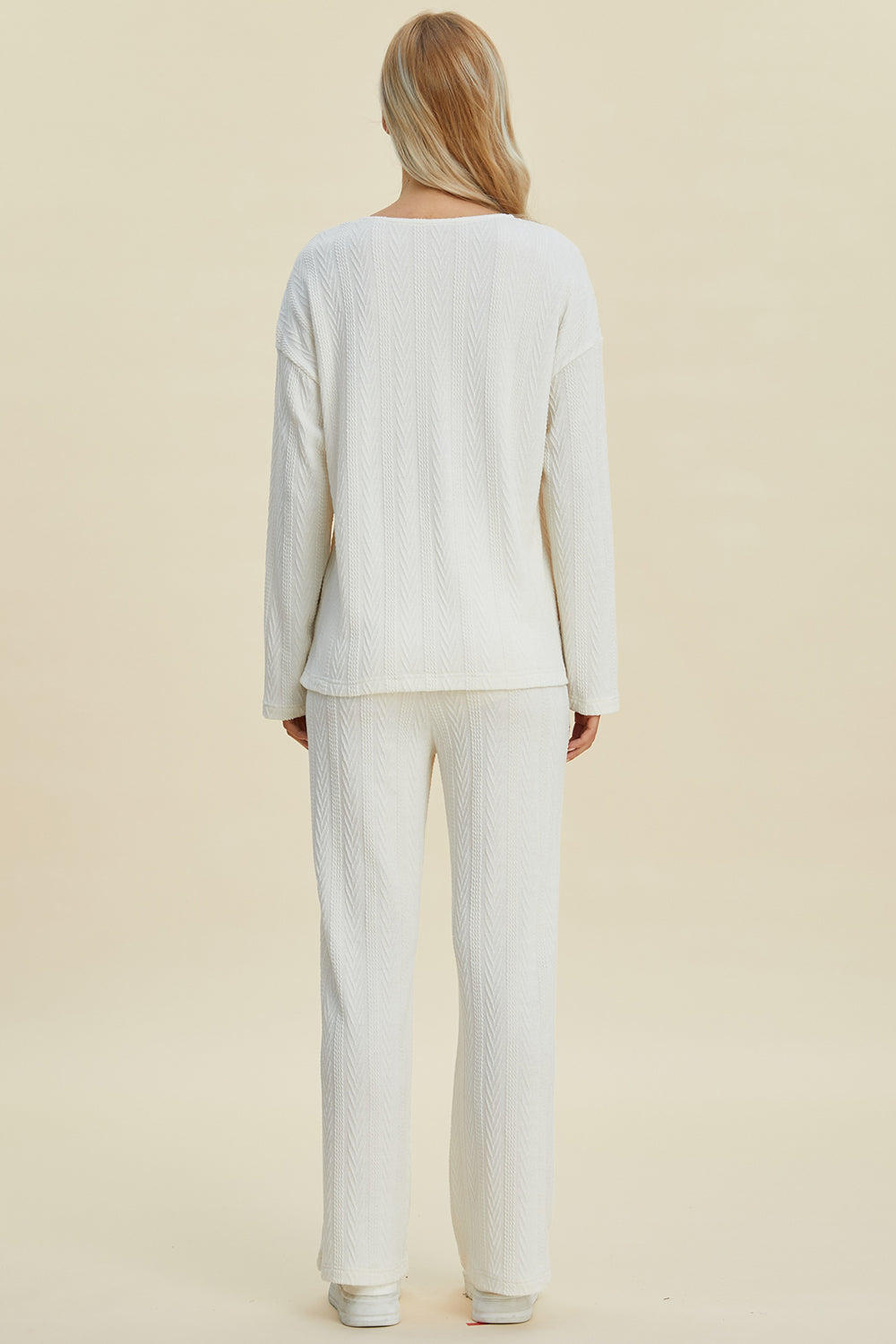 Cable-knit long sleeve top and pants set in off-white, featuring a buttoned design and slight stretch for comfort.