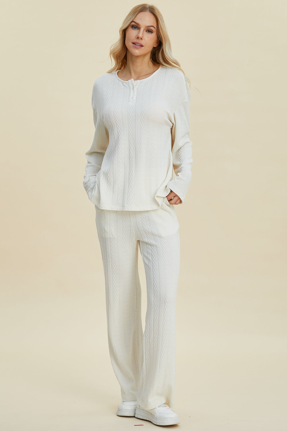 White cable-knit long sleeve top and pants set with button detail, slightly stretchy, made of 95% polyester and 5% spandex.