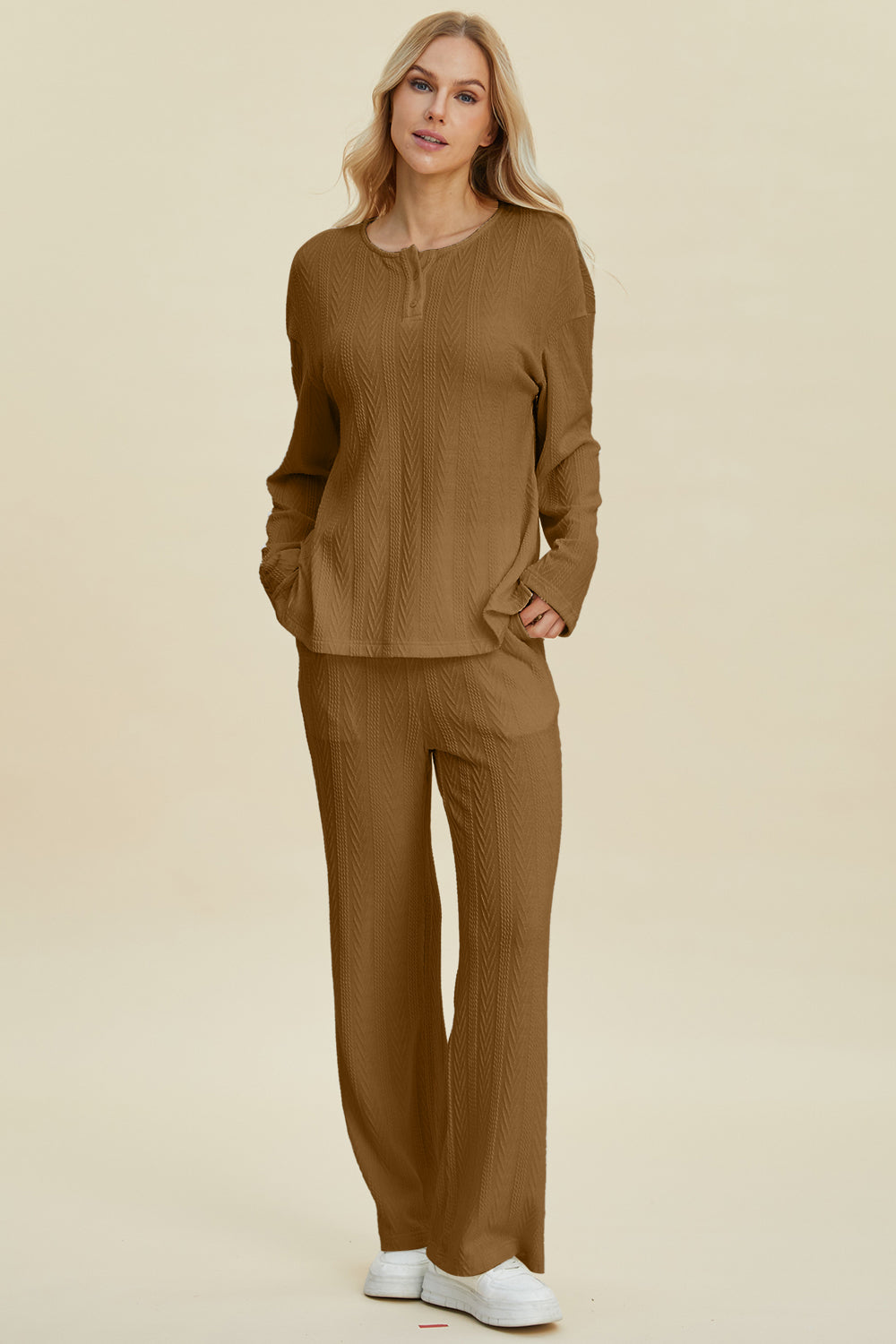 Woman wearing cable-knit long sleeve top and pants set in brown, featuring buttoned design and slightly stretchy polyester blend.