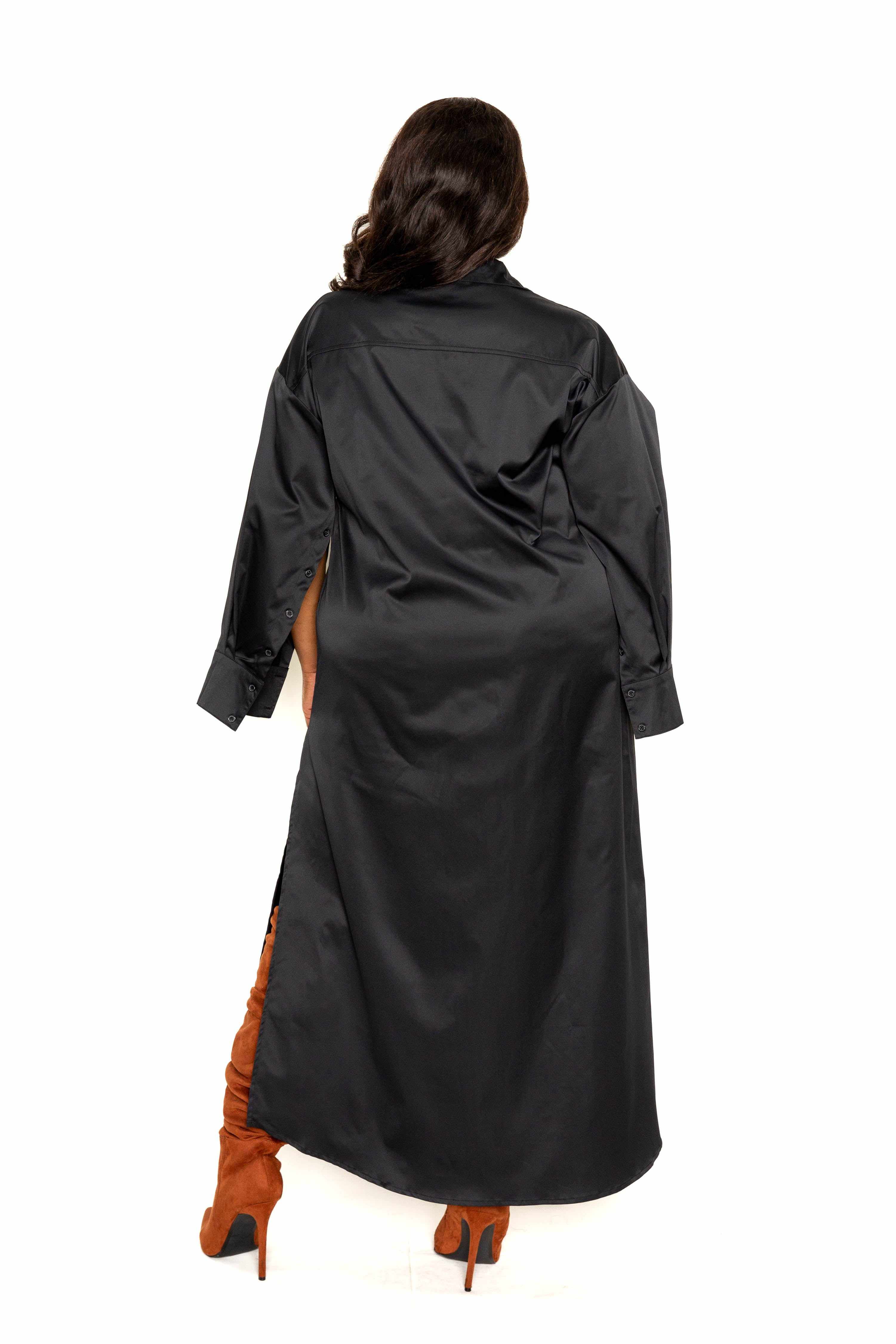 Plus-size model wearing black cape sleeve shirt dress, back view, showcasing elegant design and smooth polyester fabric.