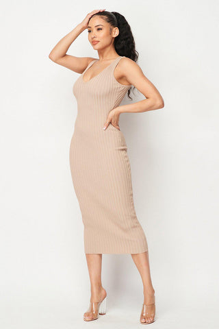 Woman wearing Carmen Ribbed Knit Midi Dress in beige, featuring an intricate ribbed design, perfect for stylish and comfortable wear.