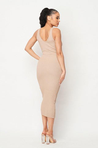 Woman wearing Carmen Ribbed Knit Midi Dress in beige, showcasing intricate ribbed design and V-neck back, side view.