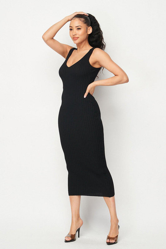 Woman wearing Carmen Ribbed Knit Midi Dress in black, featuring intricate ribbed design, styled with heels, showcasing elegant fit.