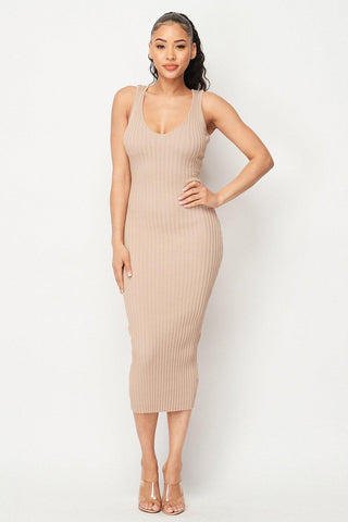 Woman wearing Carmen Ribbed Knit Midi Dress in beige, showcasing elegant and comfortable ribbed design made from 100% viscose.