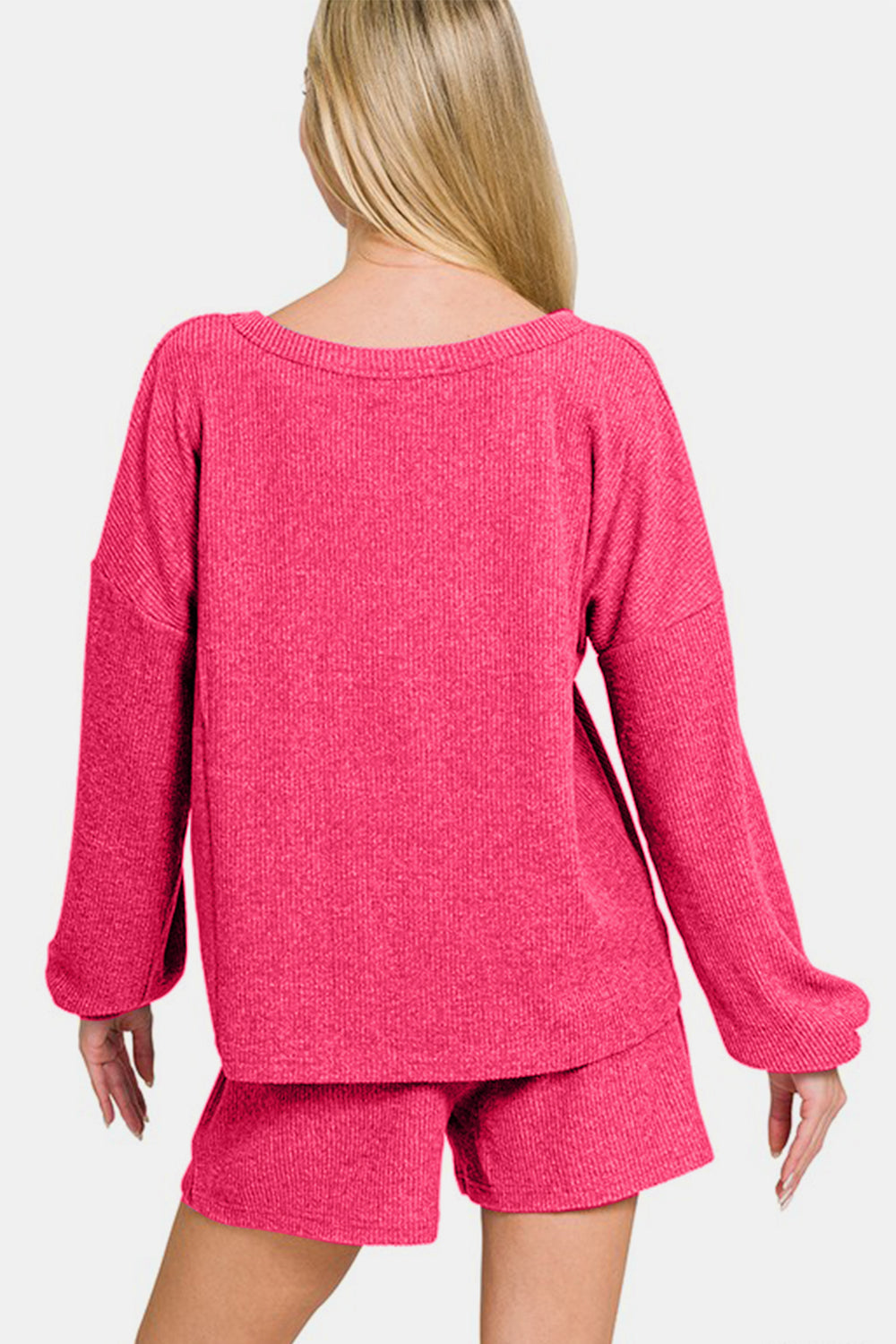 Woman wearing pink Zenana V-Neck Long Sleeve Ribbed Top and Shorts Set, a stylish and comfortable two-piece casual outfit.