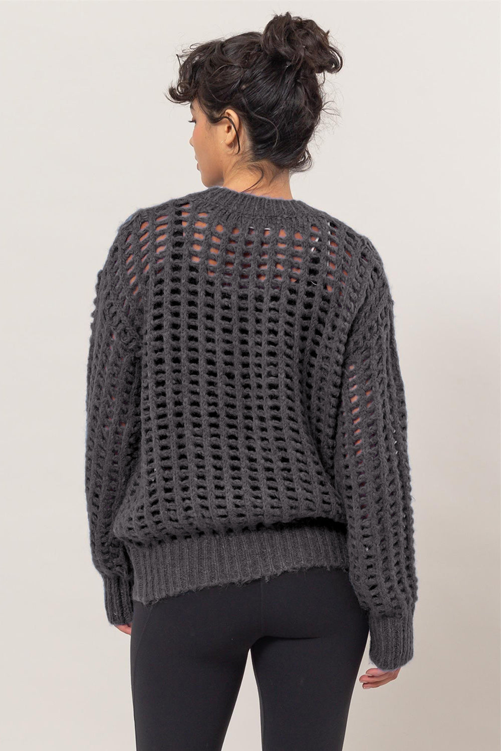 Woman wearing a HYFVE openwork round neck long sleeve knit cover up with plaid detailing, viewed from the back.