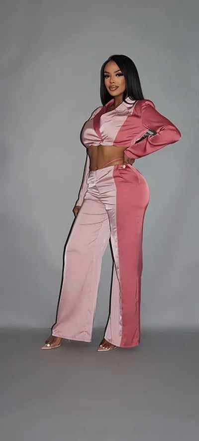 Woman wearing a blush colorblock crop blazer with matching low rise wide leg pants set, featuring pockets, against a gray background.