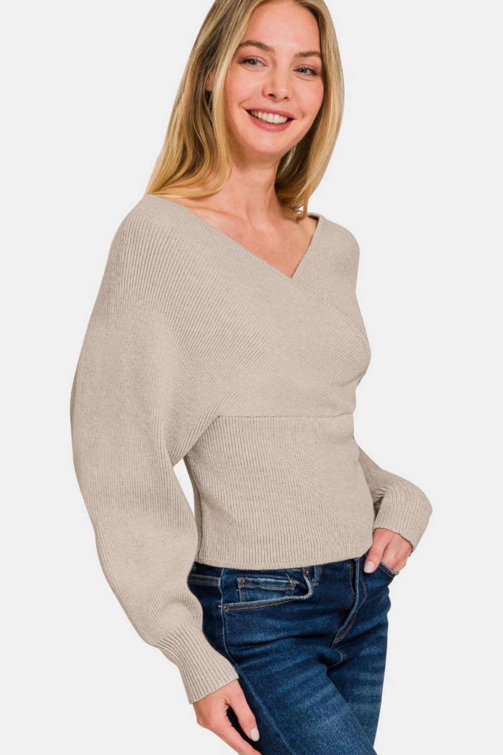 Woman wearing cross wrap rib long sleeve sweater in beige, showcasing elegant and versatile style for casual and work settings.