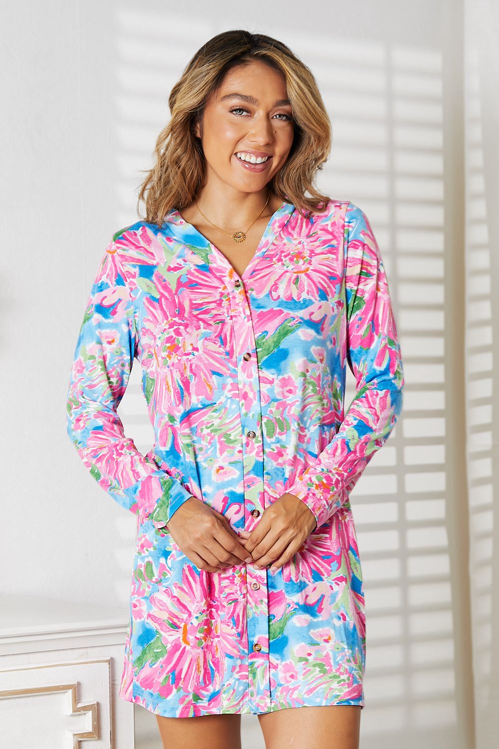 Woman wearing a vibrant floral long sleeve cardigan in pink and blue, showcasing a chic and versatile style for any occasion.