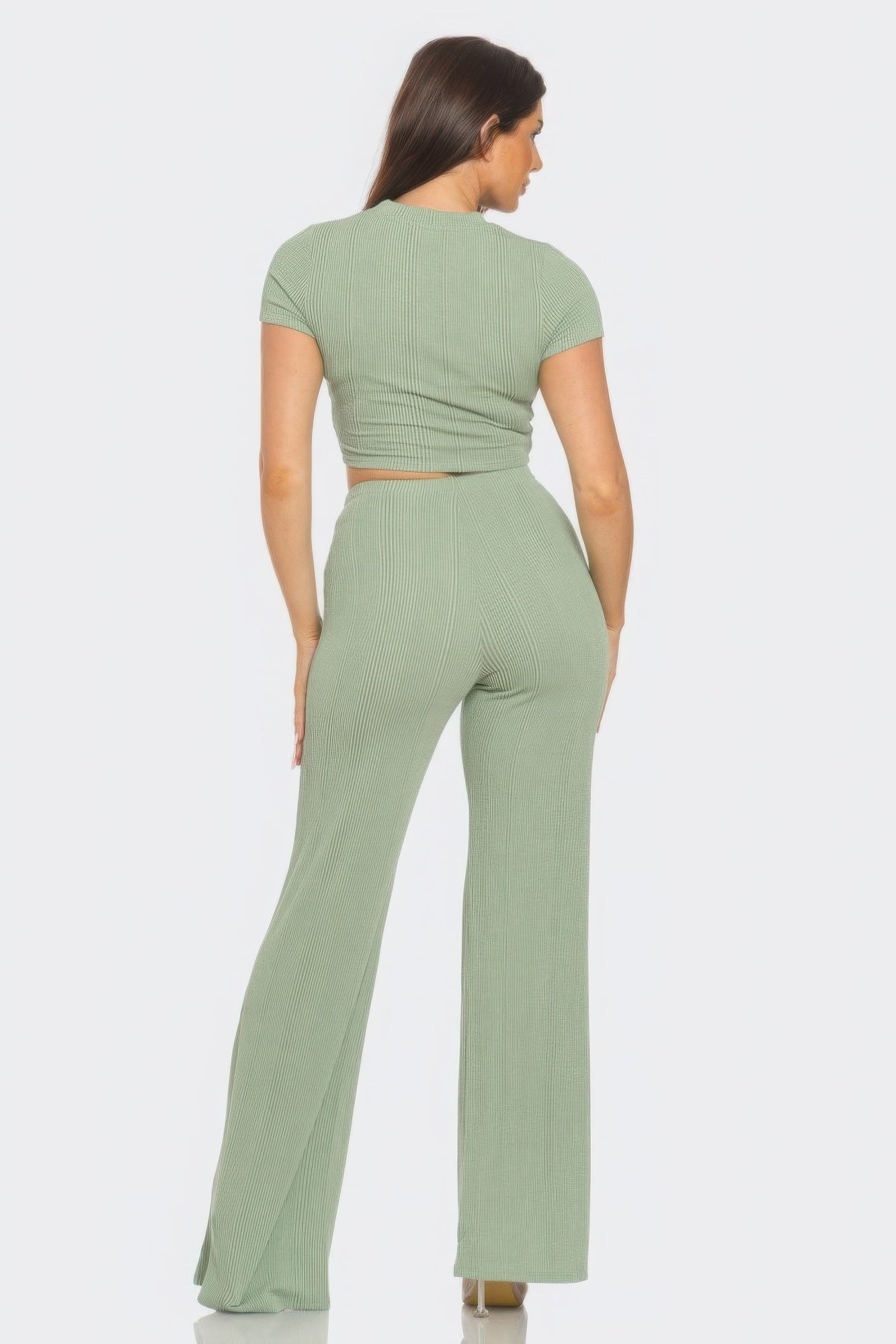 Woman in green front twist crop top and flare pants set, showcasing rib knit fabric and retro-inspired silhouette.