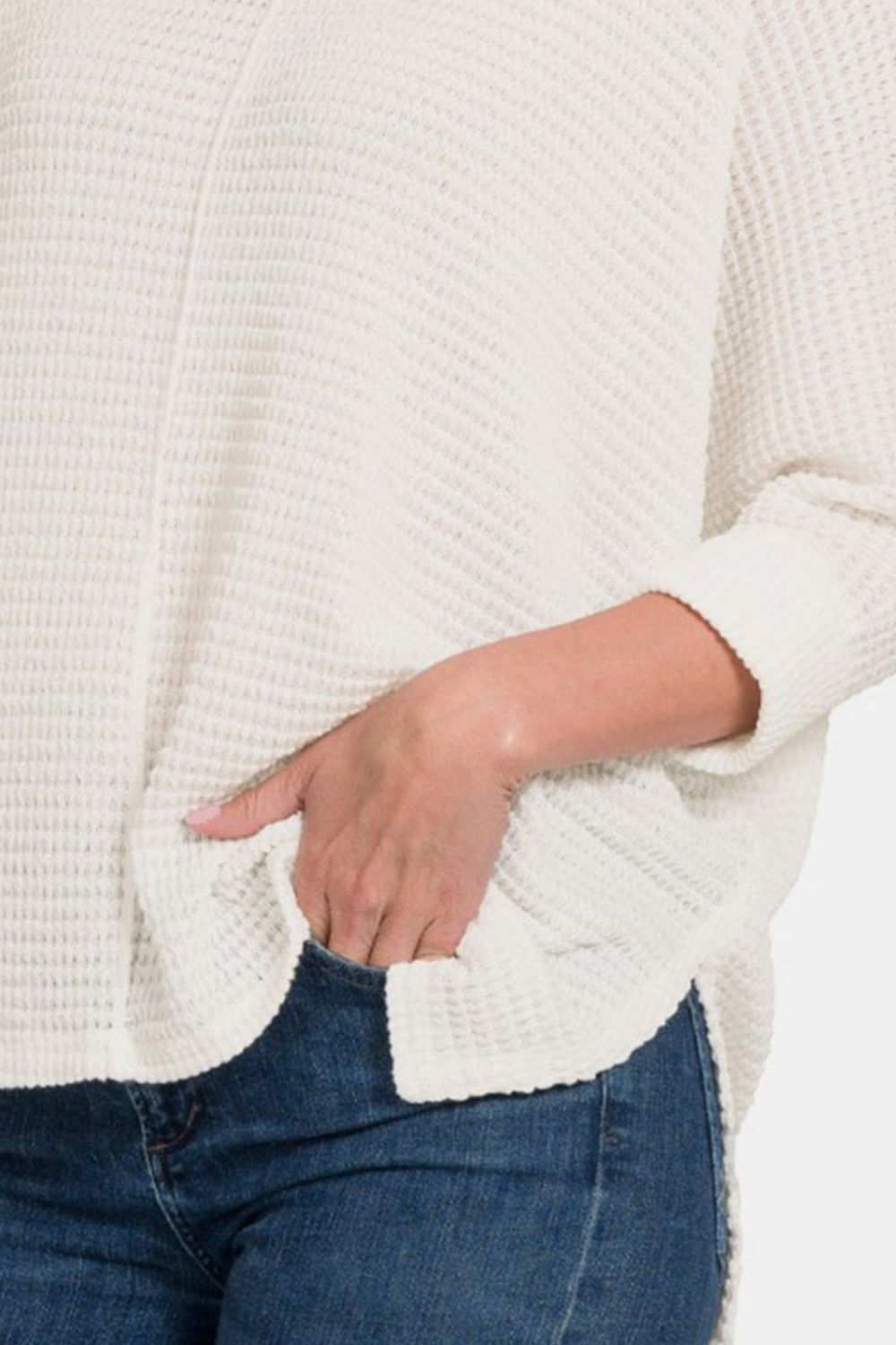 White round neck high-low slit knit top paired with blue denim jeans