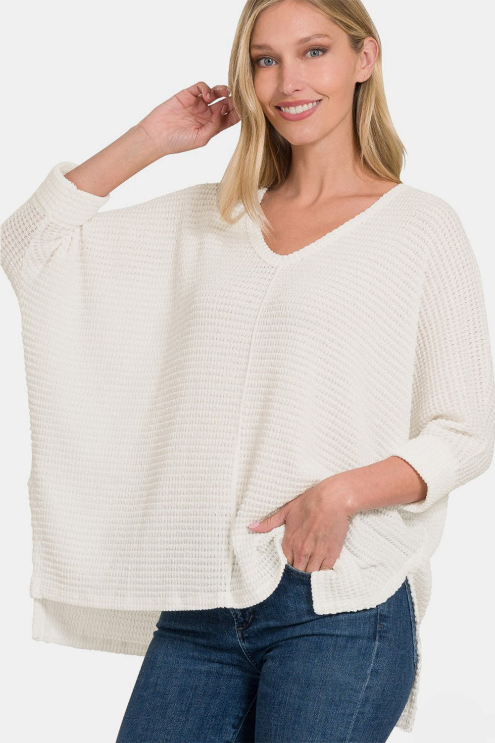 Woman wearing a cozy full size round neck high-low slit knit top with a modern design and versatile style.