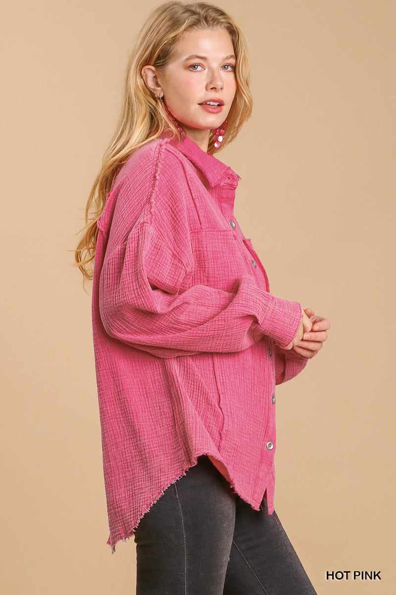 Hot pink mineral wash button down top with high low hem, side view on model.