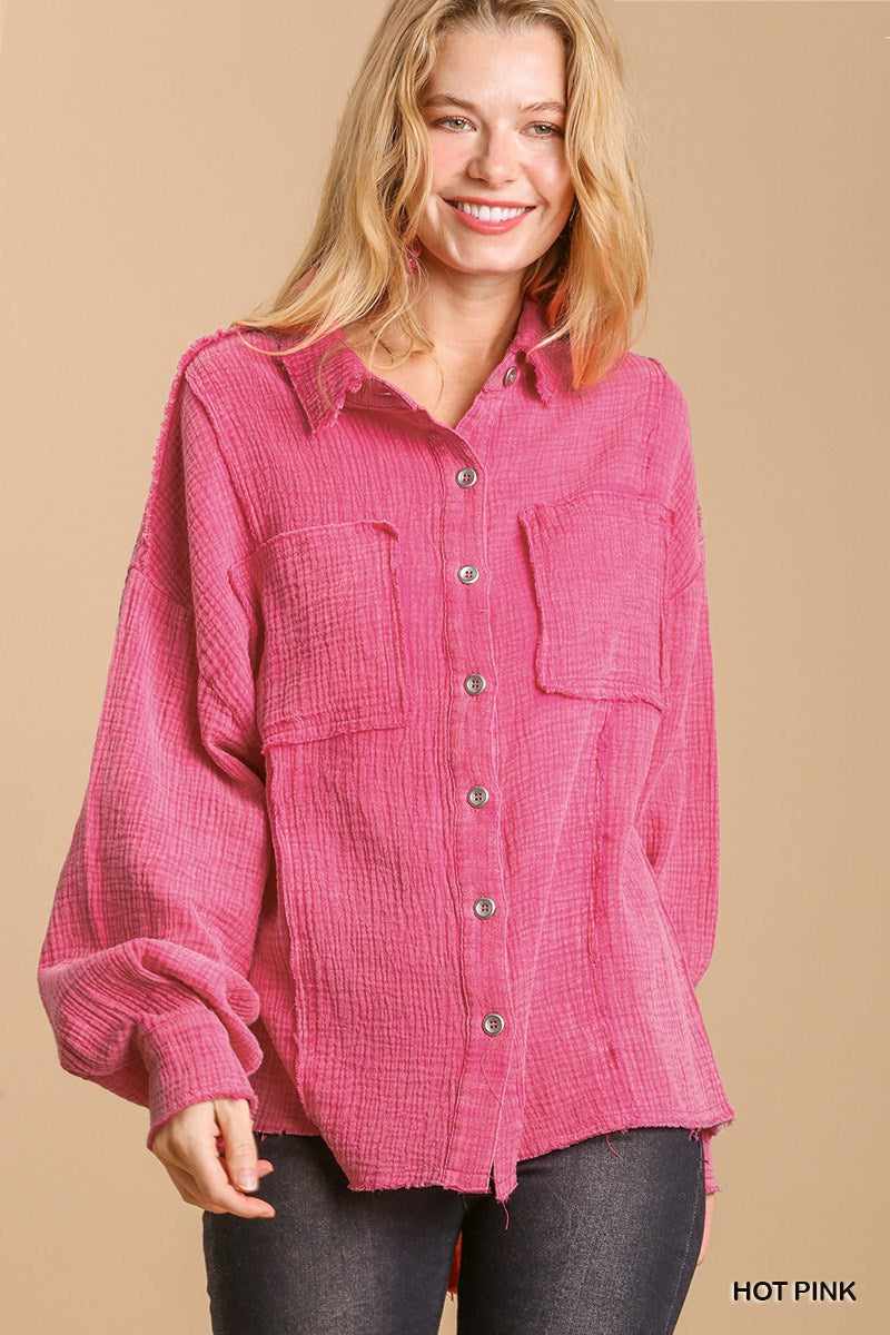 Hot pink mineral wash button-down top with high low hem, featuring front pockets and long sleeves, worn by smiling model.