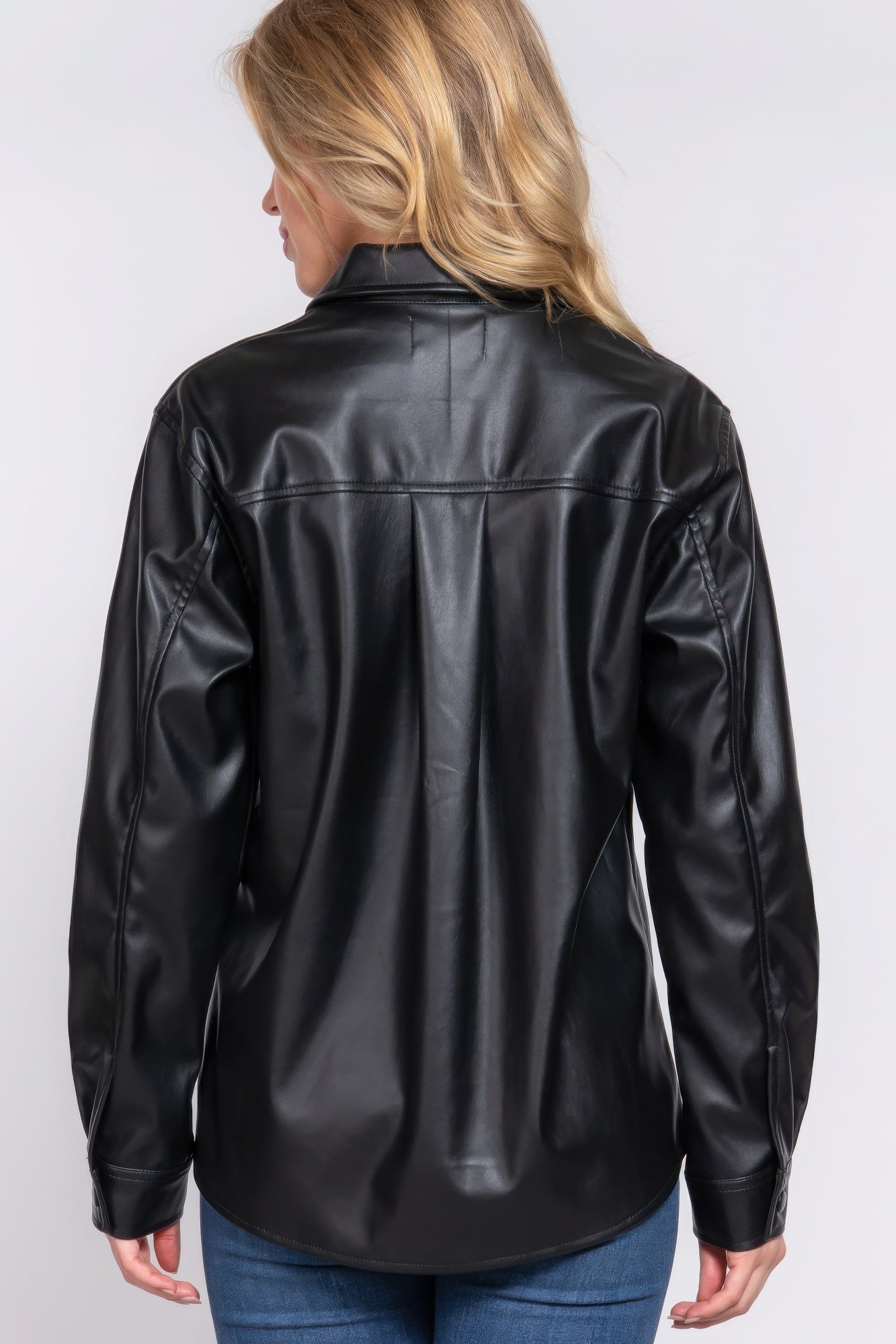 Woman wearing black faux leather shacket with long sleeves, perfect for layering and elevating casual outfits.