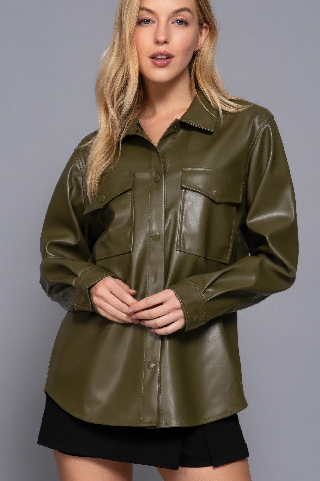 Woman wearing olive faux leather shacket with long sleeves, showcasing a chic and versatile look for layering in various outfits.