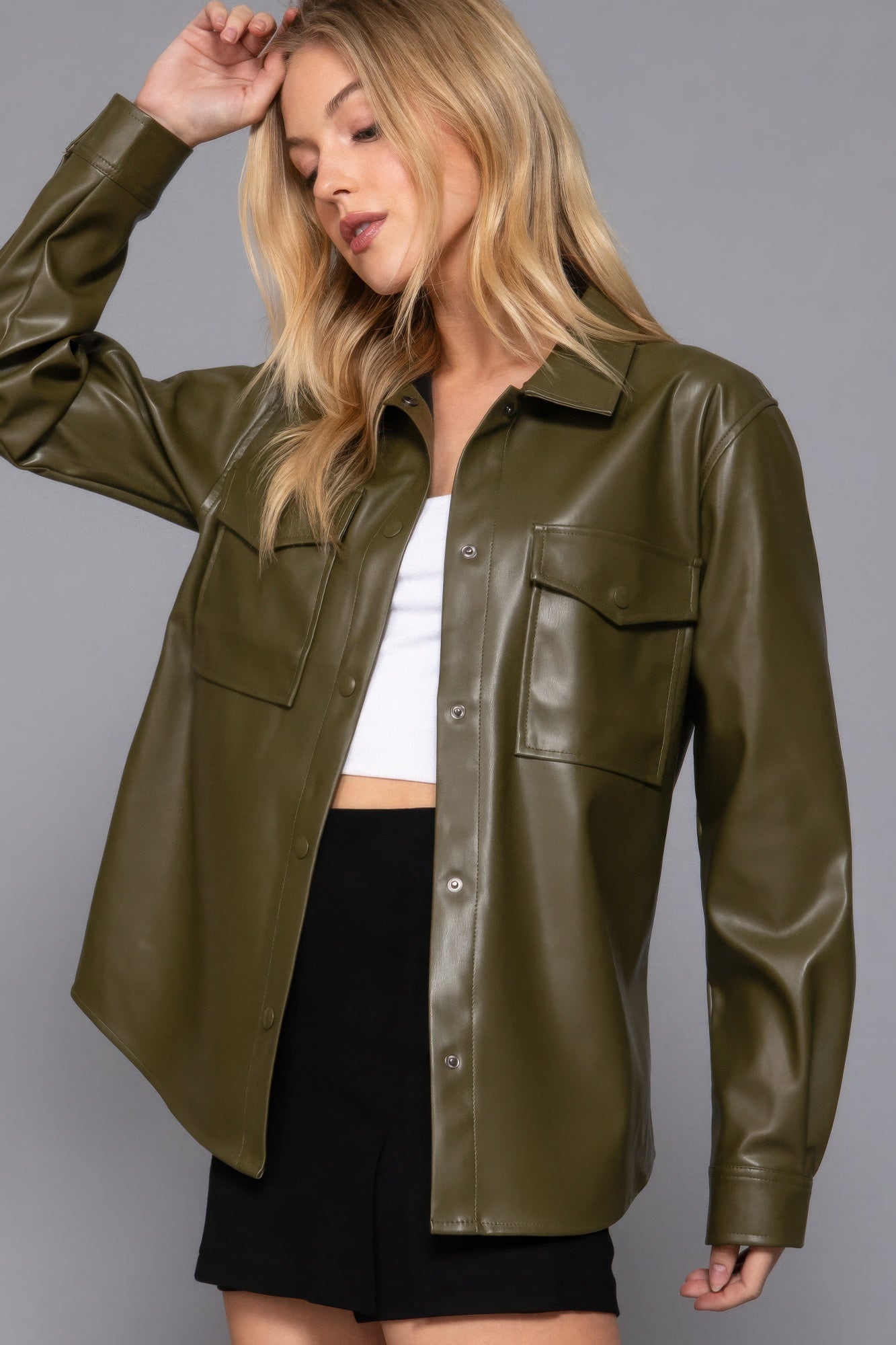 Olive faux leather shacket with long sleeves, worn by a model, showcasing a chic layering piece for versatile styling and comfort.