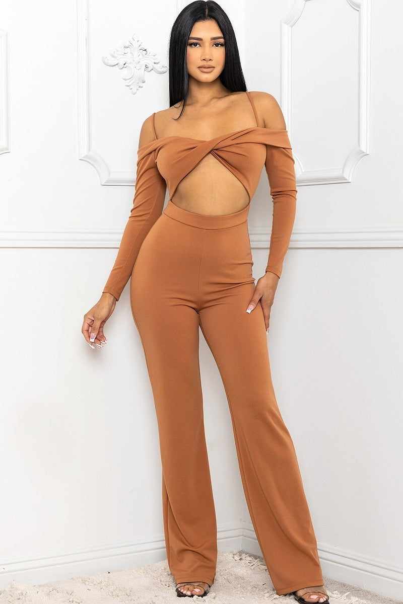 Cinnamon open shoulder jumpsuit with cutout detail, spaghetti straps, twist bust, long sleeves, and bell bottoms.