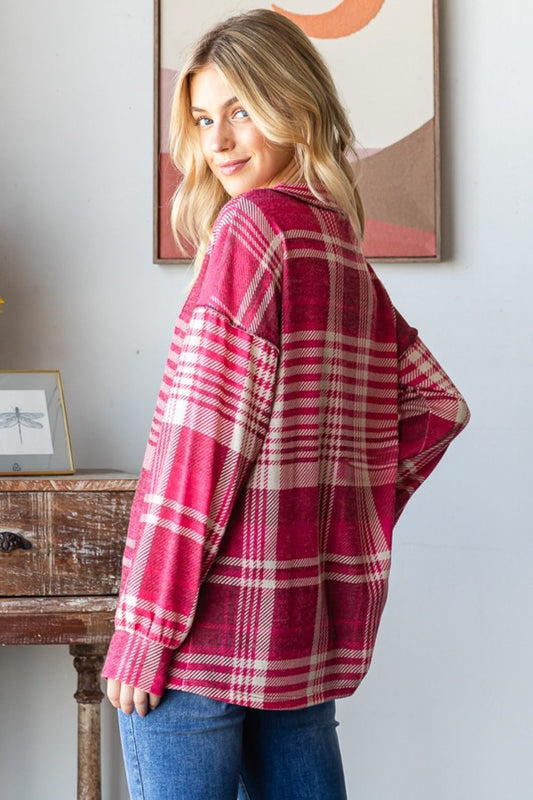 Woman wearing plaid drop shoulder V-neck T-shirt with exposed seams and relaxed fit in a chic, modern room setting.