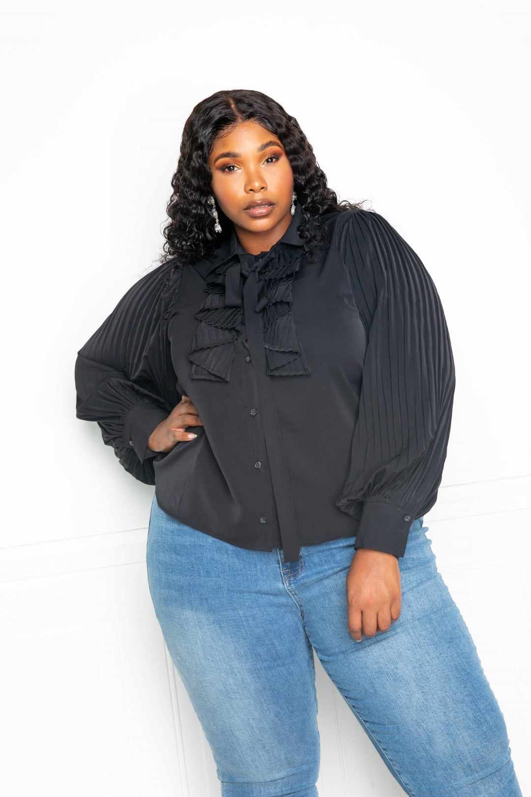 Black pleated sleeve blouse with waterfall frill and bow, plus-size model wearing 1XL, styled with blue jeans.