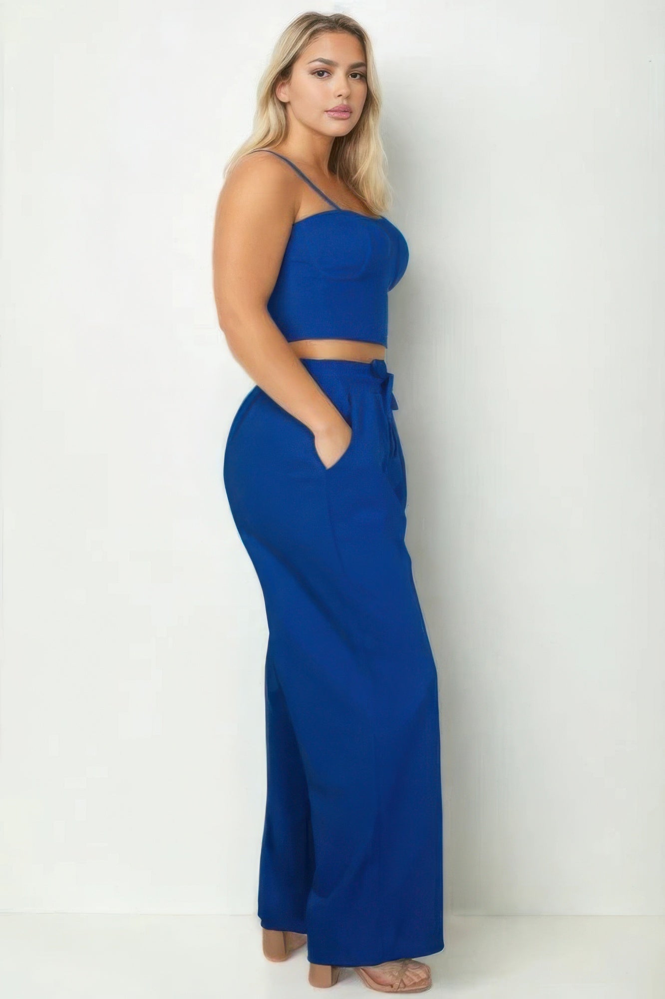 Plus size model wearing a royal blue bustier crop cami top and slant pocket straight pants set, showcasing chic and sophisticated style.