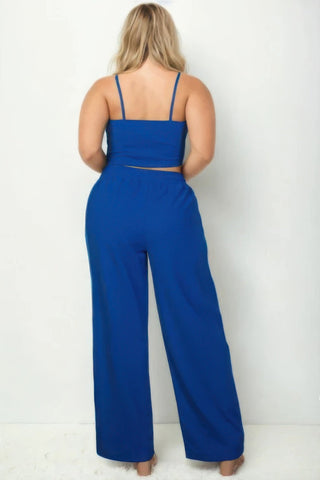 Plus size model wearing a royal blue bustier crop cami top with matching slant pocket straight pants, showcasing a chic coordinated set.