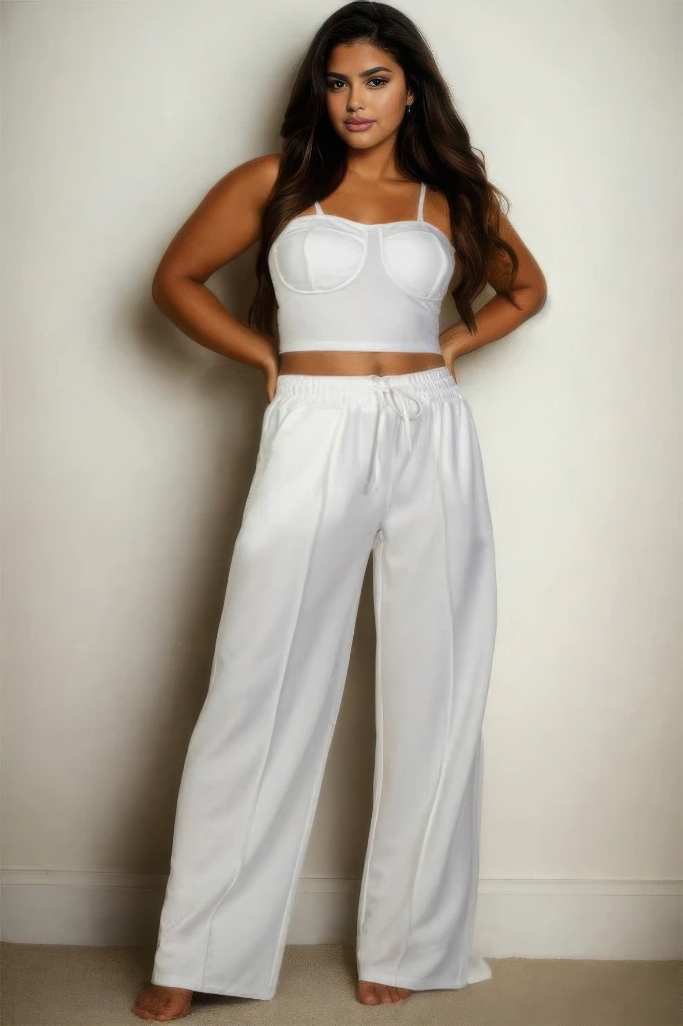 Plus-size woman wearing a chic bustier crop cami top and slant pocket straight pants in white, showcasing stylish and comfortable fashion.