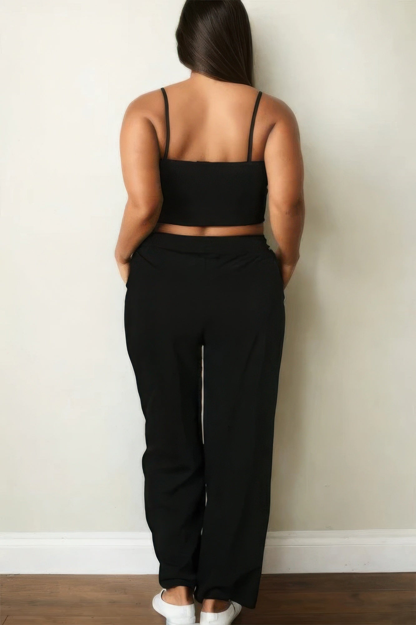 Woman in black bustier crop cami top and straight pants set, rear view showcasing comfortable and chic design.