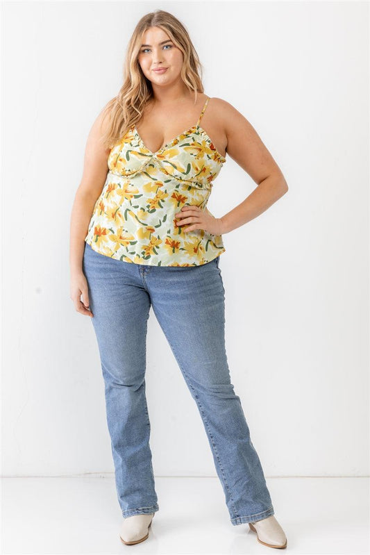 Plus size floral print sage woven tank top with ruffle, V-neckline, and adjustable straps, styled with jeans.