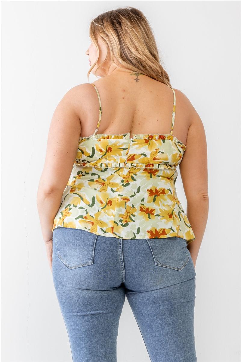 Woman wearing plus size floral print sage woven tank top with ruffles and adjustable straps, showcasing back view with blue jeans.