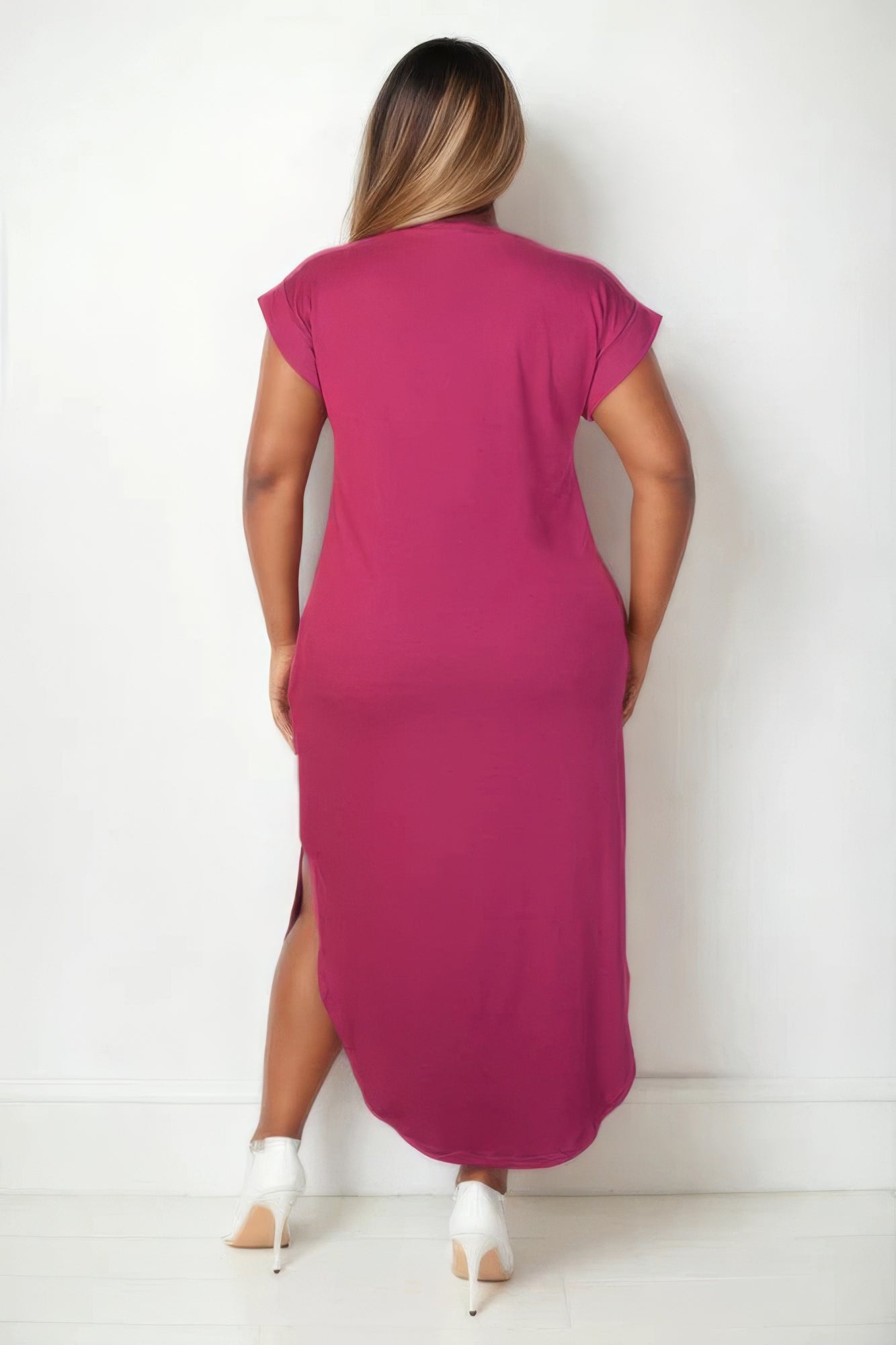 Woman wearing chic plus size maxi dress with a V-neck and batwing sleeves in vibrant magenta, showcasing back view.