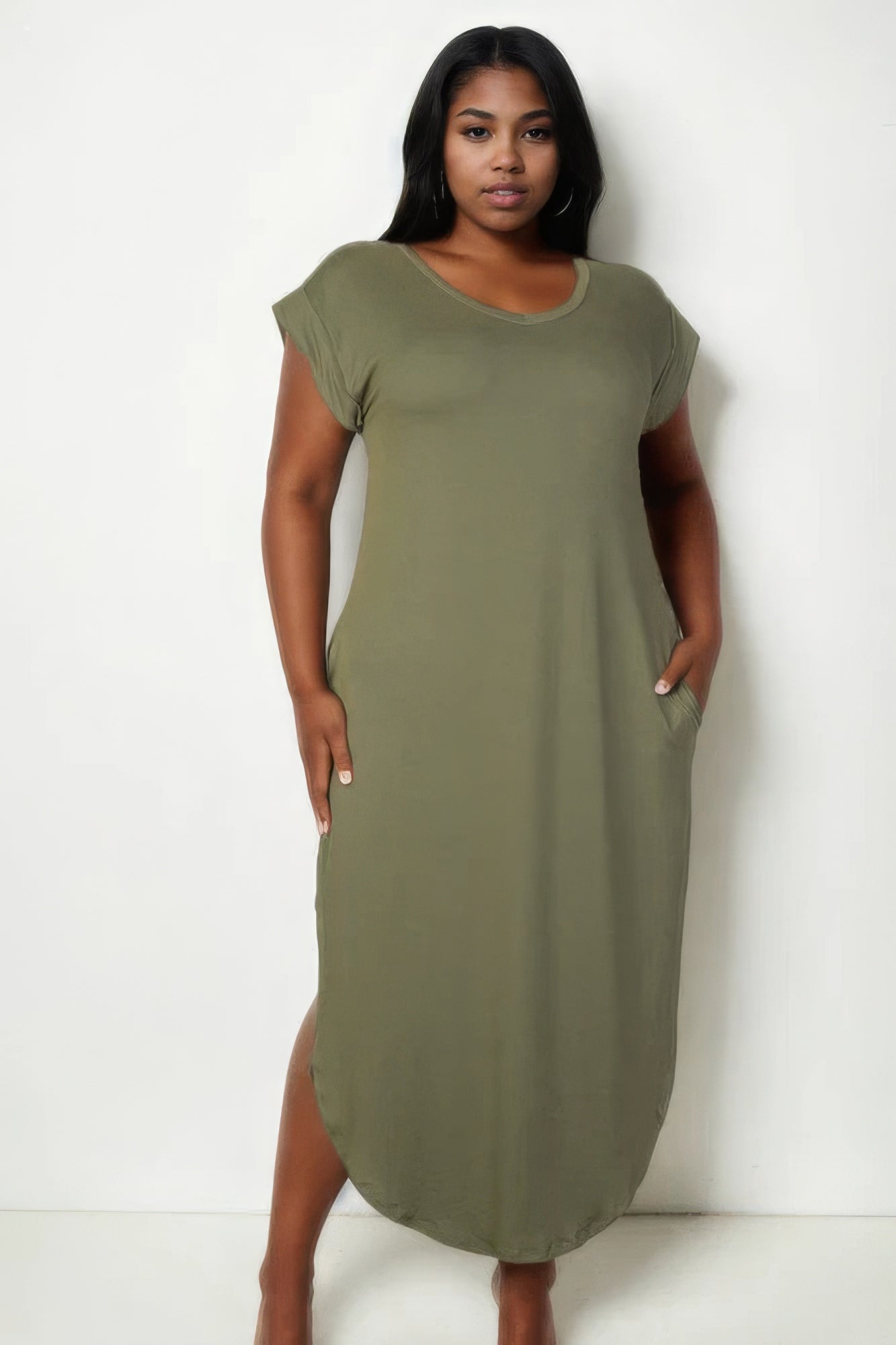 Plus size woman wearing a chic olive V neck maxi dress with batwing sleeves and concealed pockets for a sophisticated look.