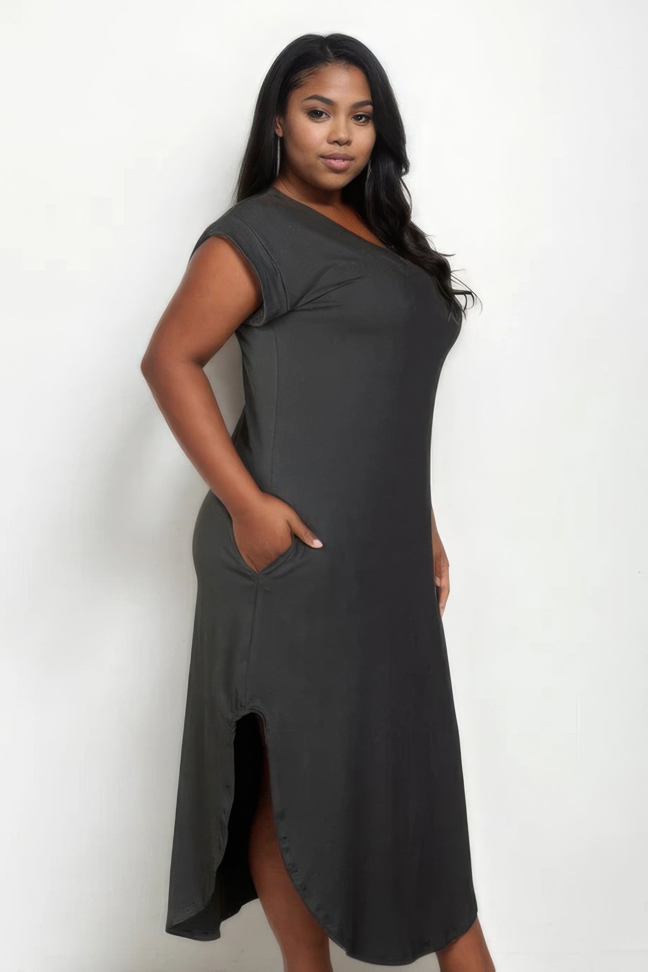 Plus size woman wearing chic olive V-neck maxi dress with batwing sleeves and pockets, showcasing its comfortable fit and elegant style.